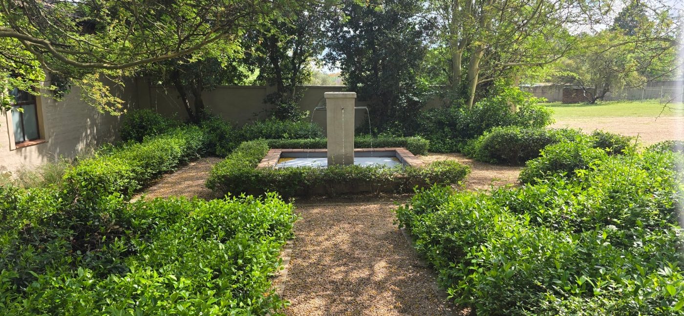 Formal garden courtyard with a stone fountain and clipped hedges